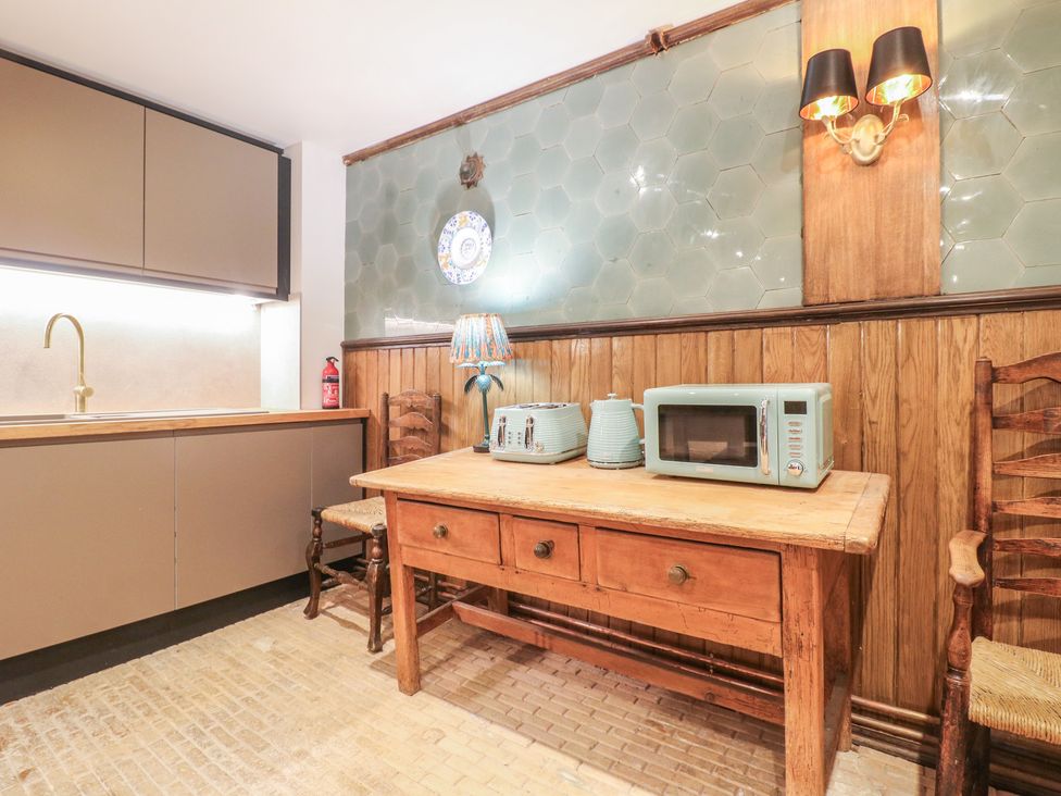 A kitchen with a table and microwave at Shrewsbury Lodge in Great Haywood