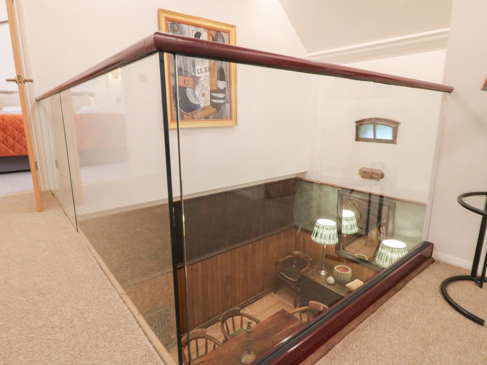 A staircase view from a hallway with a glass railing at Shrewsbury Lodge in Great Haywood