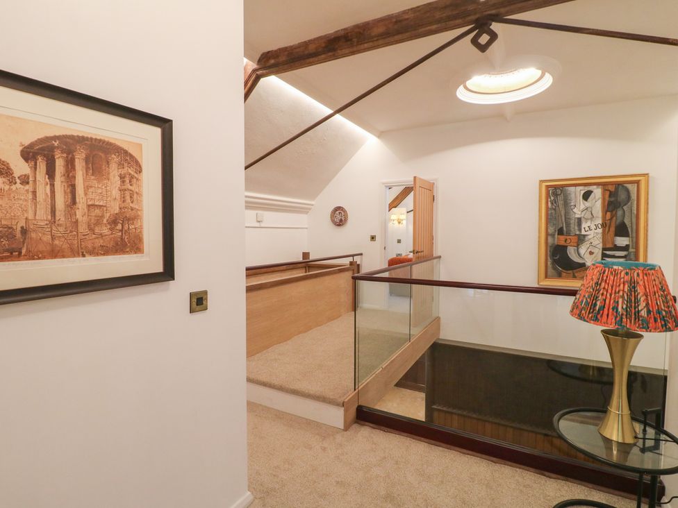 A landing with a painting, a lamp, and a handrail at Shrewsbury Lodge in Great Haywood