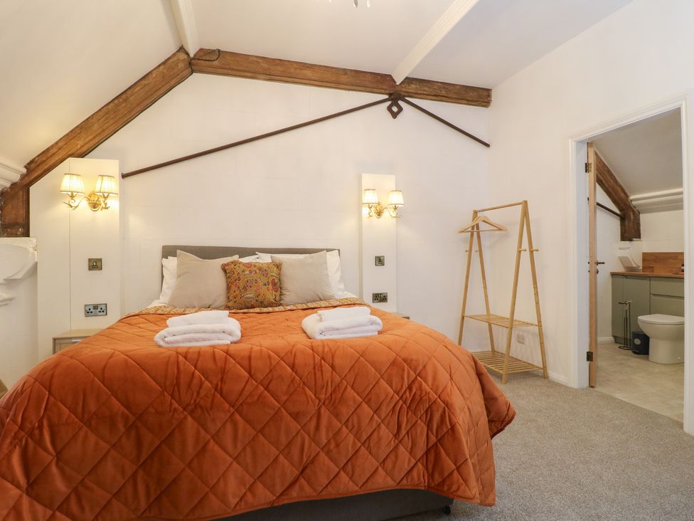 A bedroom with a bed and a clothing rack at Shrewsbury Lodge in Great Haywood