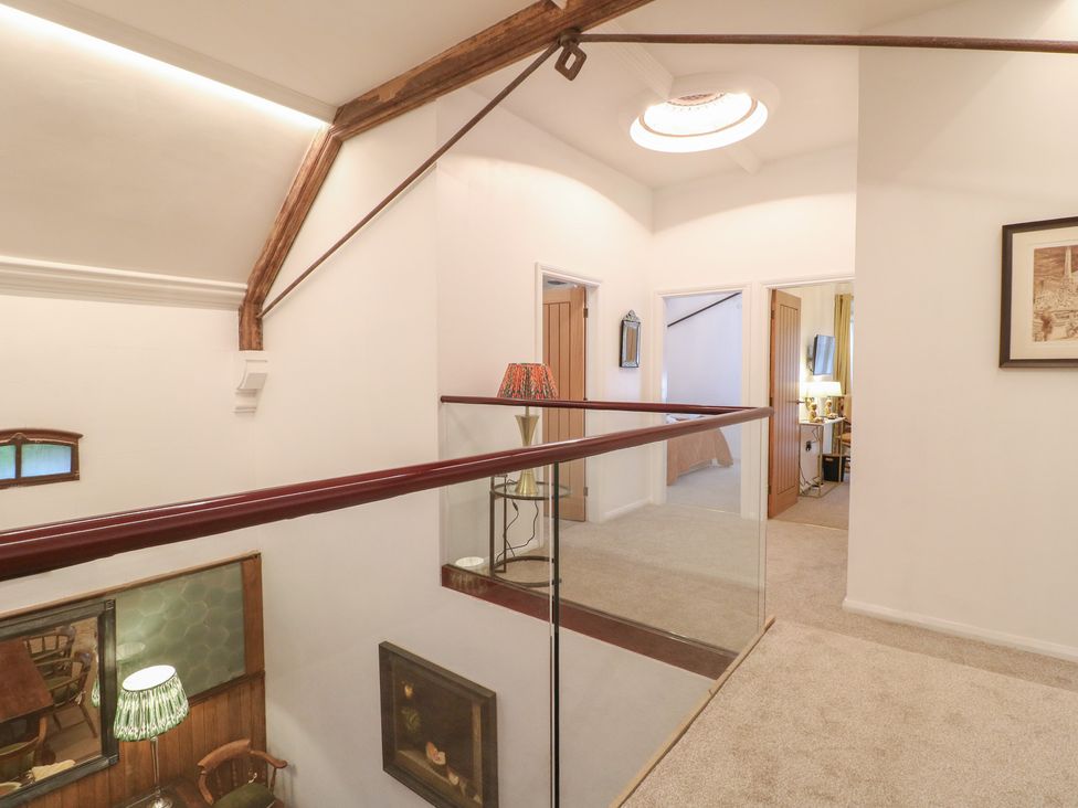 A hallway with a balcony and doors at Shrewsbury Lodge Great Haywood
