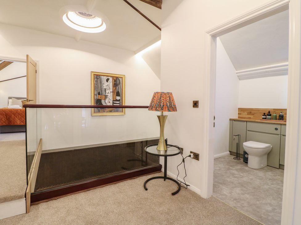 A landing area with a lamp and a bathroom door at Shrewsbury Lodge in Great Haywood