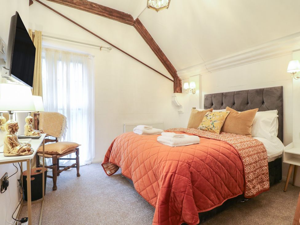 A bedroom with a double bed and a chair at Shrewsbury Lodge in Great Haywood