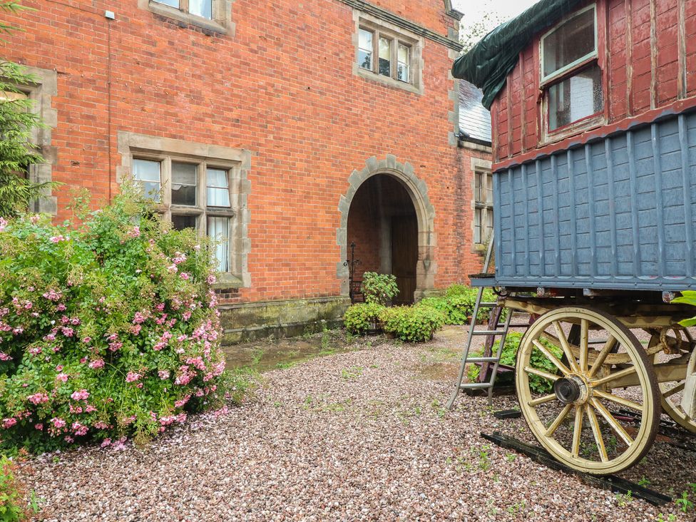 An outdoor area featuring a brick building and a wagon at Shrewsbury Lodge in Great Haywood