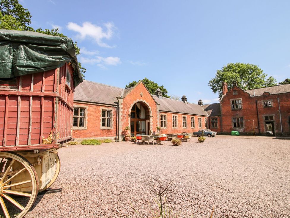 A courtyard with a building and a carriage at Shrewsbury Lodge in Great Haywood