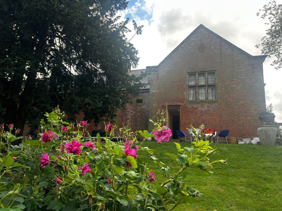 A garden with flowers in front of a building at Shrewsbury Lodge Ingestre near Great Haywood
