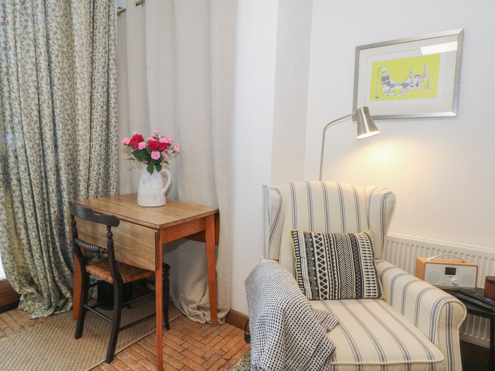 A snug area with an armchair, table, and flowers at Diamond Lodge Ingestre near Great Haywood