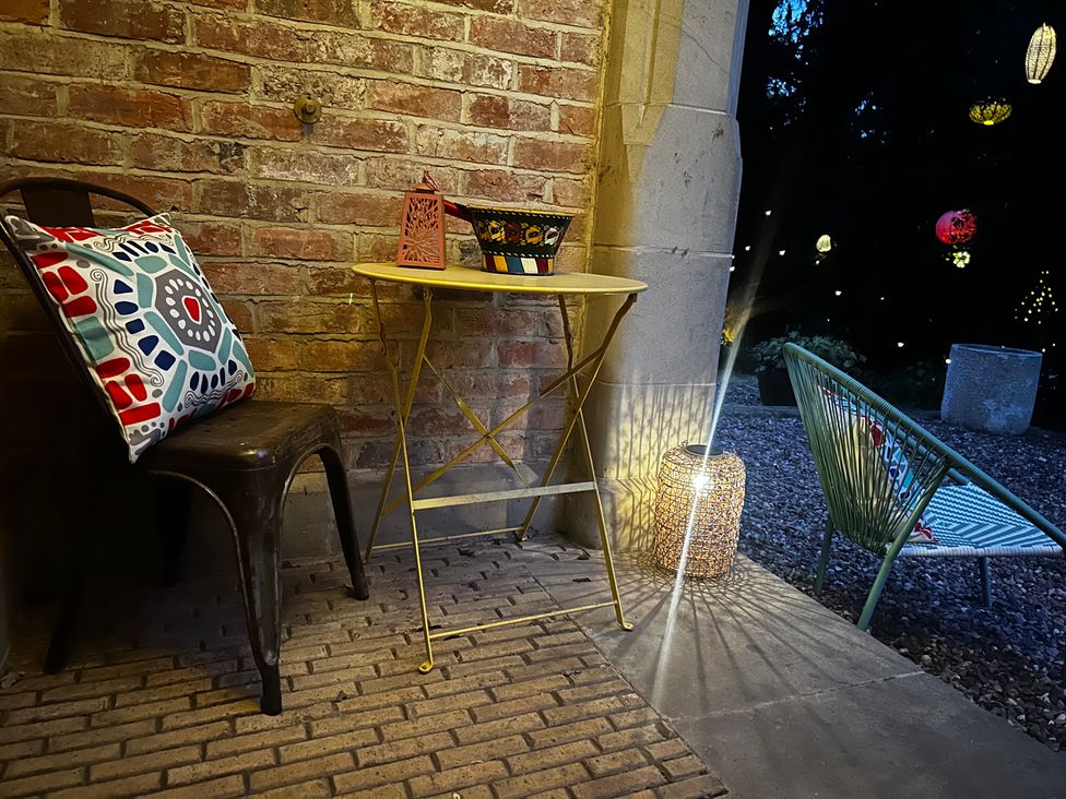 A table with a lantern and chair in an outdoor area at Diamond Lodge Ingestre near Great Haywood