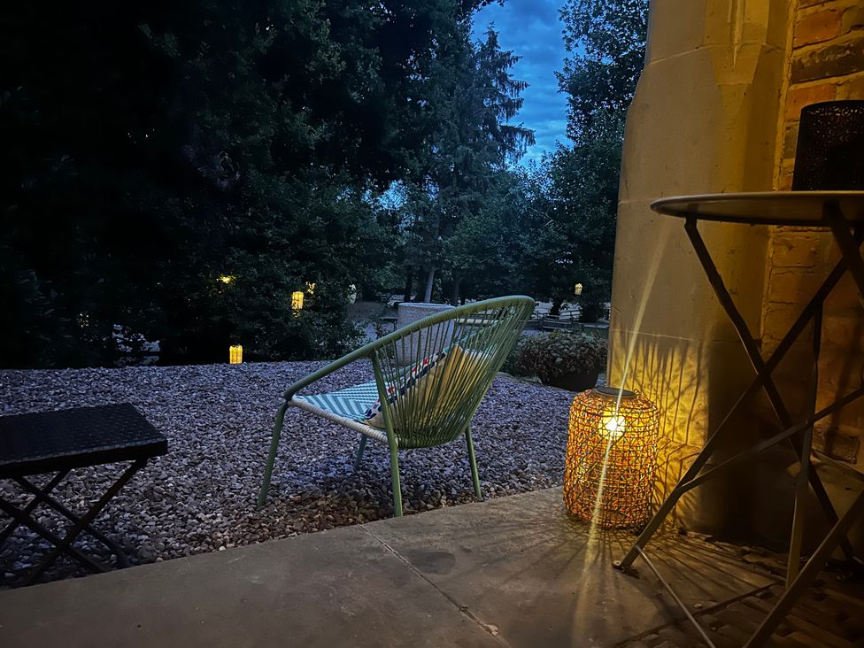 A patio area with a chair and lantern at Diamond Lodge Ingestre near Great Haywood