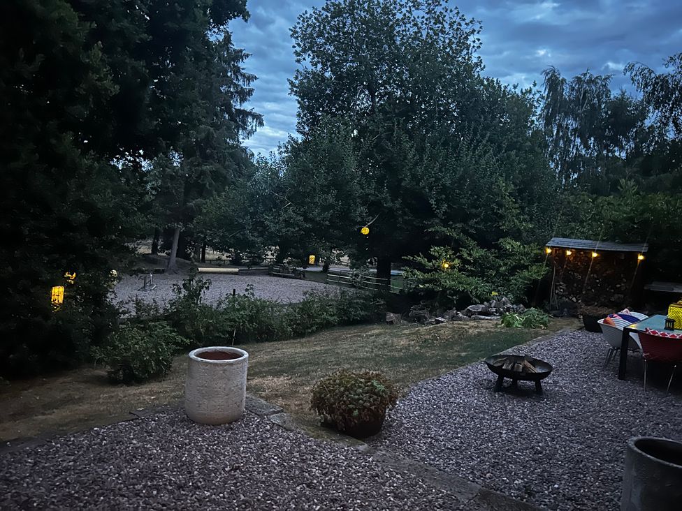 A garden with trees and a fire pit at Diamond Lodge Ingestre near Great Haywood