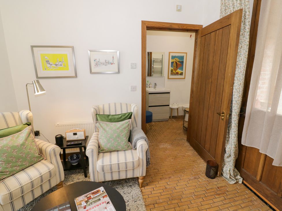 A living room with armchairs and a door leading to a bathroom at Diamond Lodge Ingestre near Great Haywood