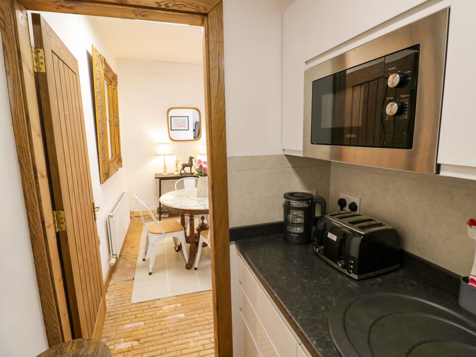 A kitchen with appliances and a door leading to a dining area at Diamond Lodge Ingestre near Great Haywood