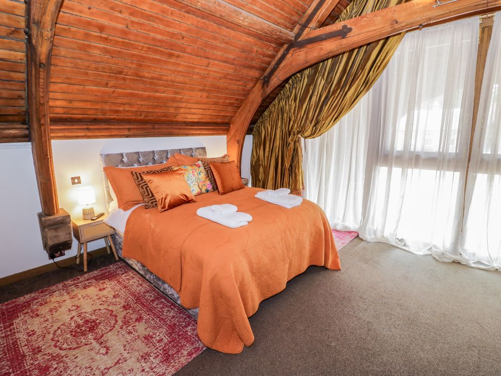A bedroom with an orange bedspread and pillows at Diamond Lodge Ingestre near Great Haywood