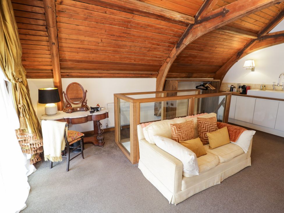 A loft with a sofa and kitchenette at Diamond Lodge in Ingestre near Great Haywood