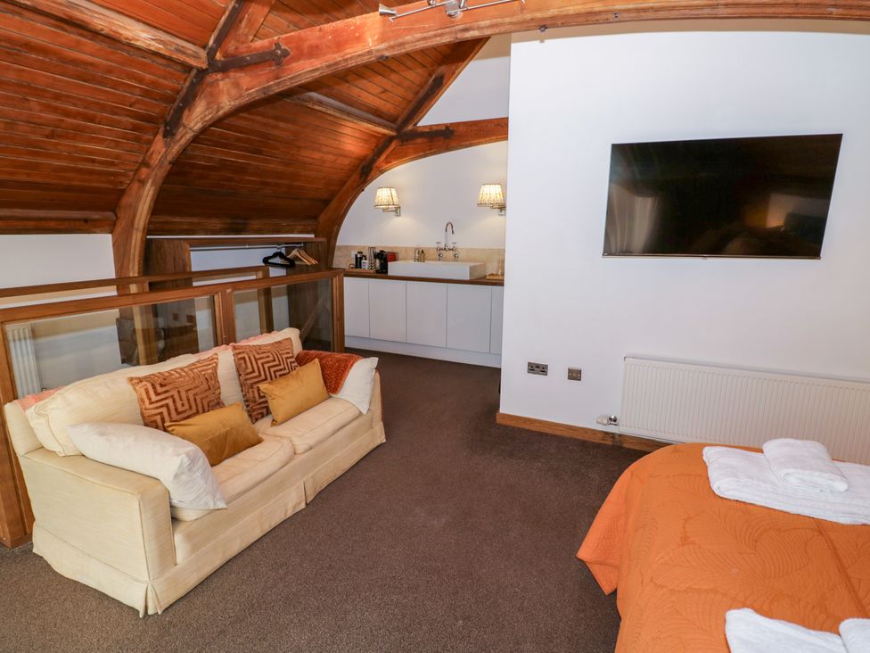 A bedroom with a sofa and kitchenette at Diamond Lodge Ingestre near Great Haywood