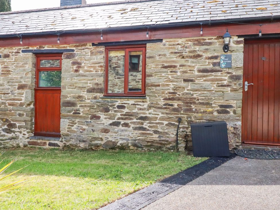 An outdoor view of a stone cottage with windows and doors at Cosy Cottage in Dobwalls