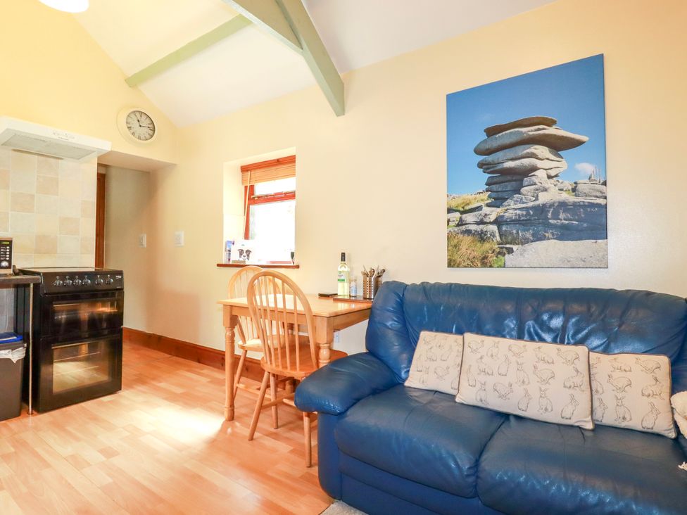 A kitchen area with an oven and dining table at Cosy Cottage in Dobwalls