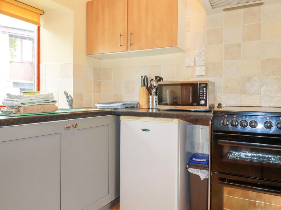 A kitchen with appliances and utensils at Cosy Cottage in Dobwalls