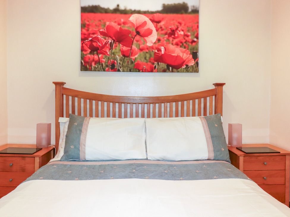 A bedroom with a bed and bedside tables at Cosy Cottage in Dobwalls