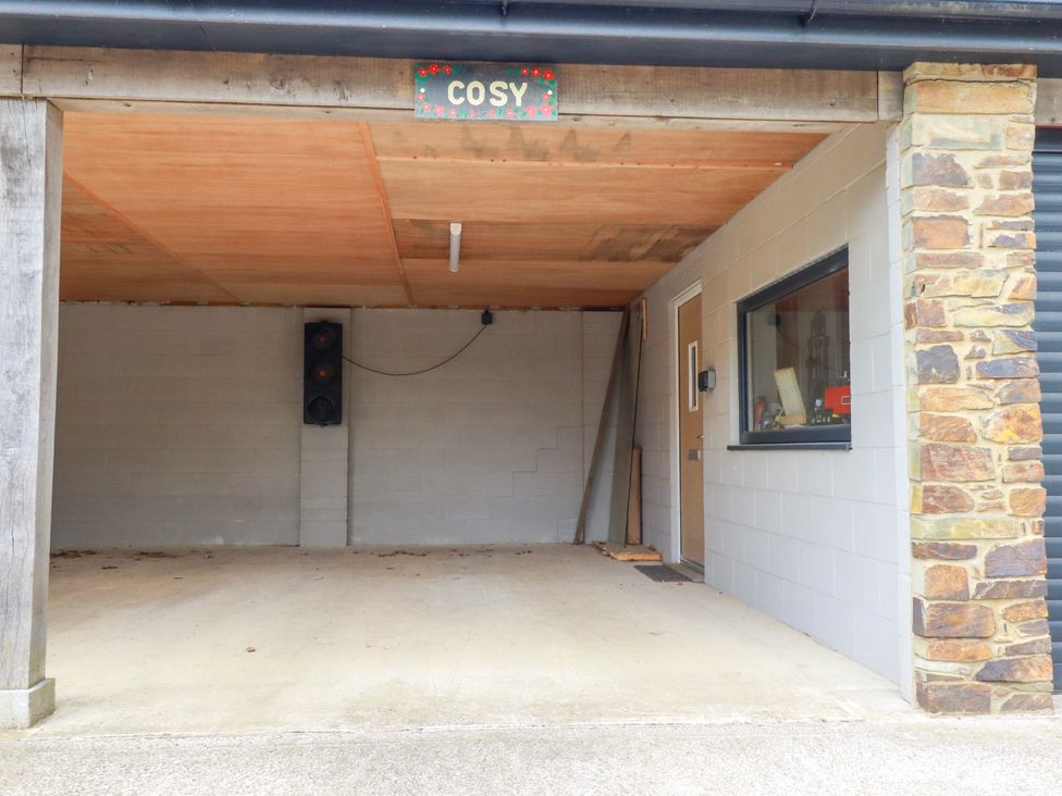 A garage with a door and window at Cosy Cottage in Dobwalls