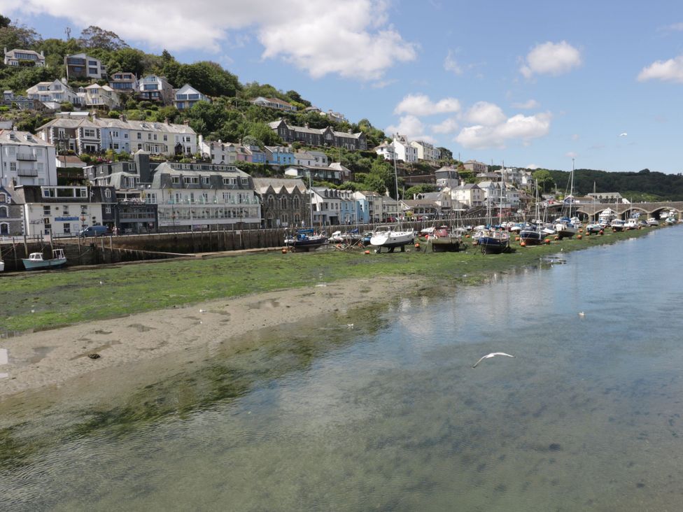 A view of buildings and boats along the shoreline at Barn Cottage in Dobwalls