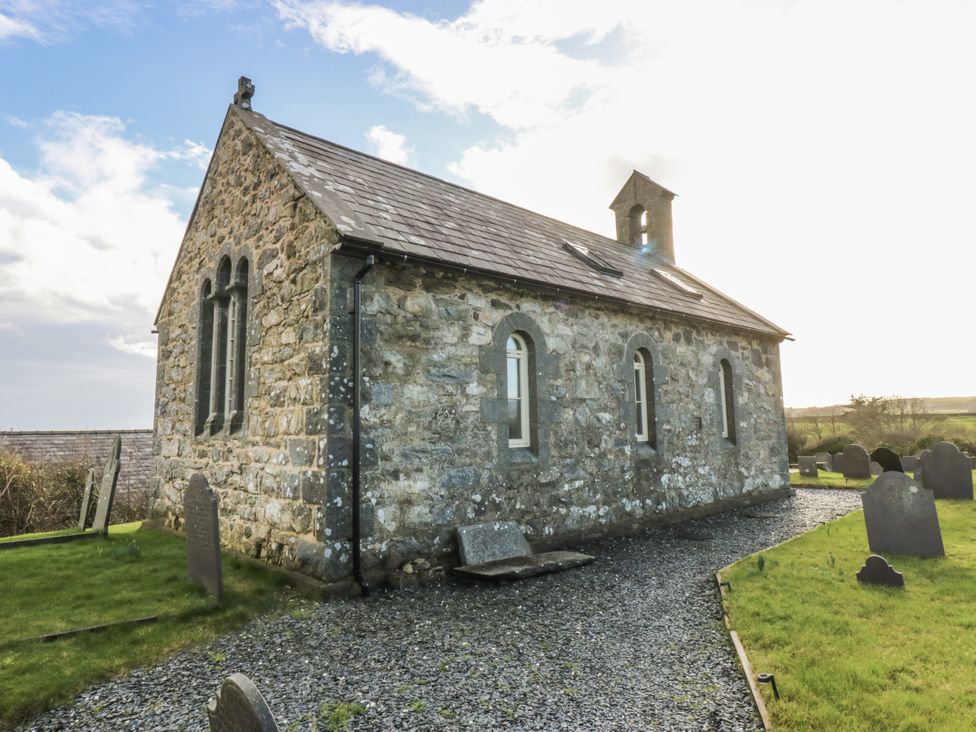 A stone church surrounded by gravestones at Eglwys St Cynfil in Penrhos near Pwllheli