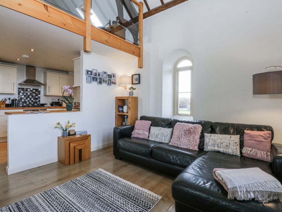 A living room with a sofa and coffee table at Eglwys St Cynfil Penrhos near Pwllheli