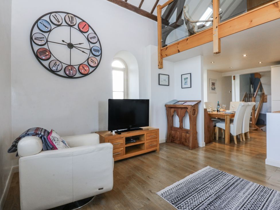 A living room with a sofa and television at Eglwys St Cynfil in Penrhos near Pwllheli