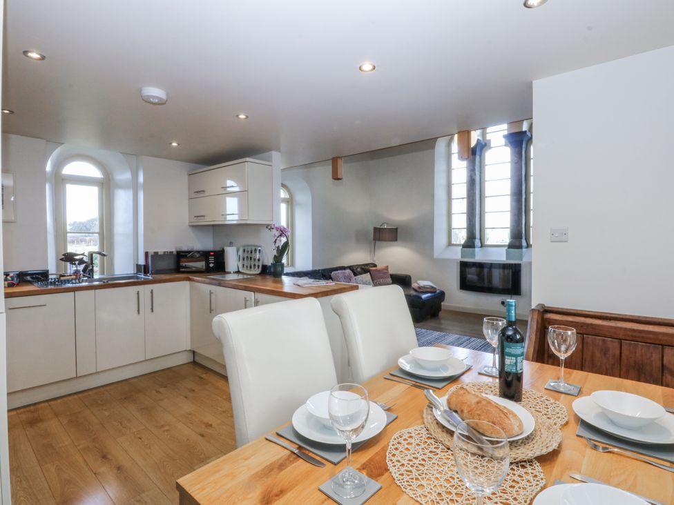 A kitchen with dining area featuring a dining table at Eglwys St Cynfil Penrhos near Pwllheli