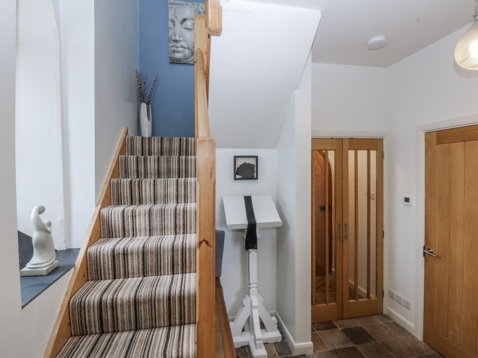 A hallway with stairs and a sculpture at Eglwys St Cynfil Penrhos near Pwllheli