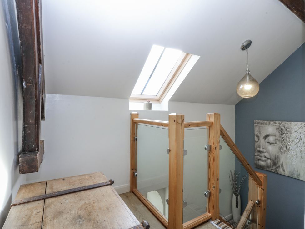 A landing area with a wooden chest and artwork at Eglwys St Cynfil Penrhos near Pwllheli