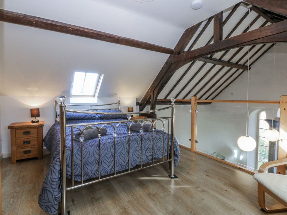 A bedroom with a bed and nightstand at Eglwys St Cynfil Penrhos near Pwllheli