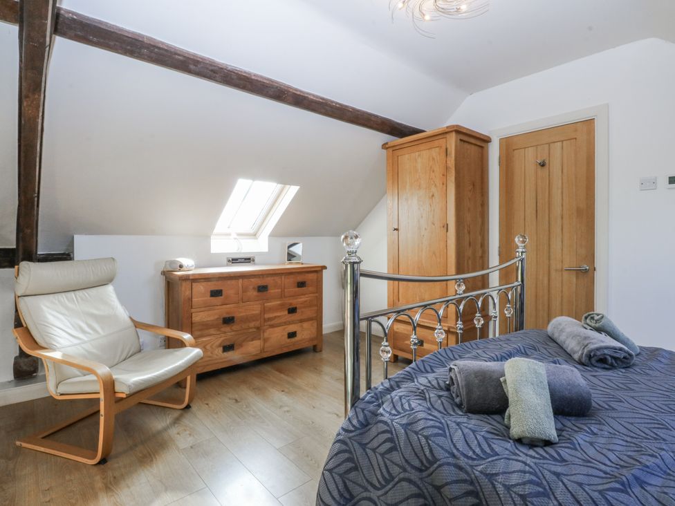 A bedroom with a bed and chest of drawers at Eglwys St Cynfil Penrhos near Pwllheli