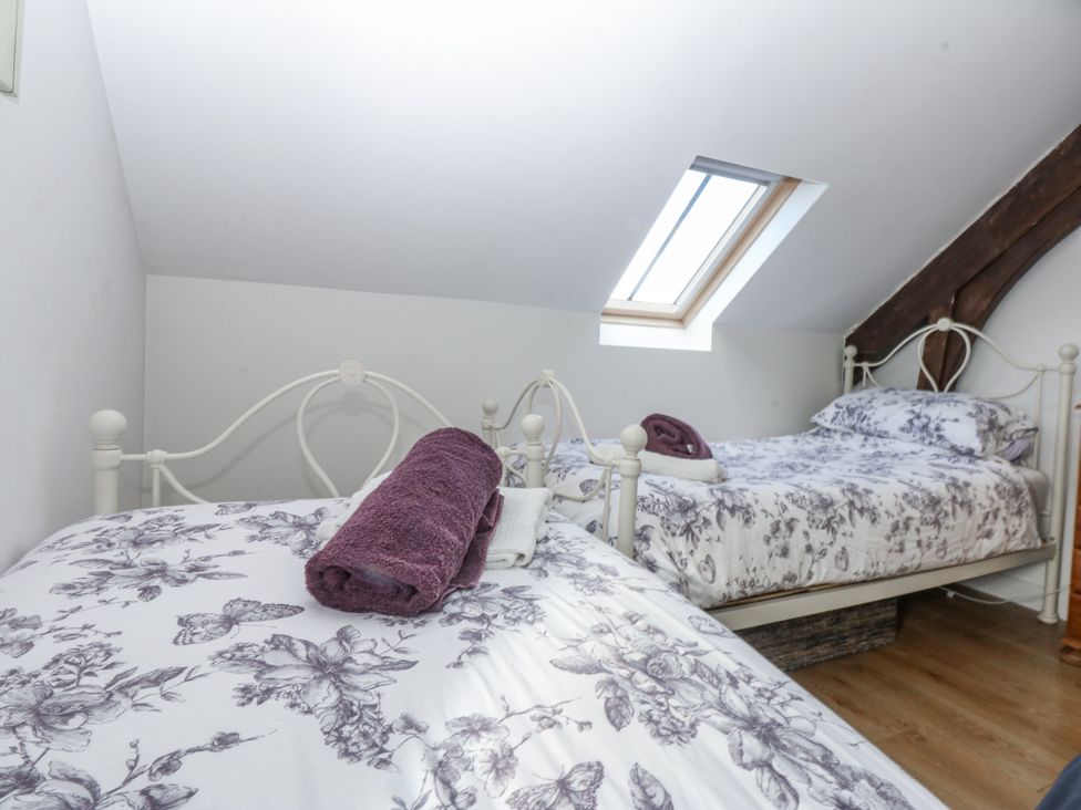 A bedroom with two beds and towels at Eglwys St Cynfil Penrhos near Pwllheli