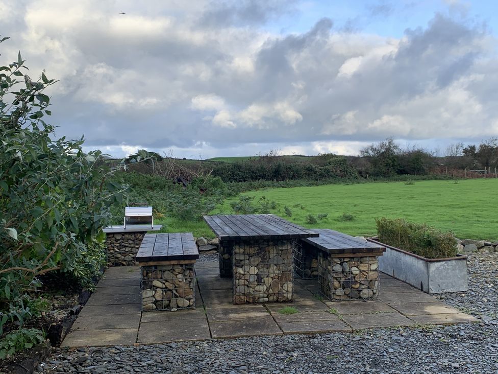 A stone table and benches in an outdoor area at Eglwys St Cynfil Penrhos near Pwllheli