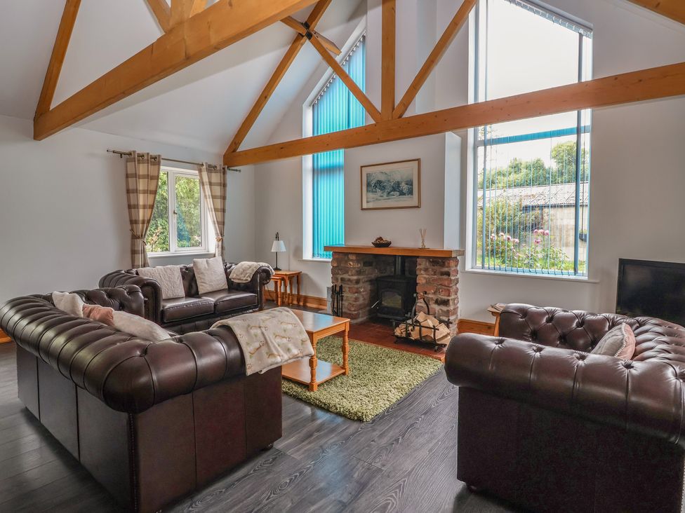A living room with sofas, a table, and a fireplace at Lillieput Lodge in Melbourne
