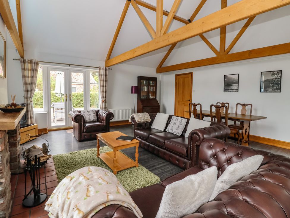 A living room with sofa and dining area at Lillieput Lodge Melbourne