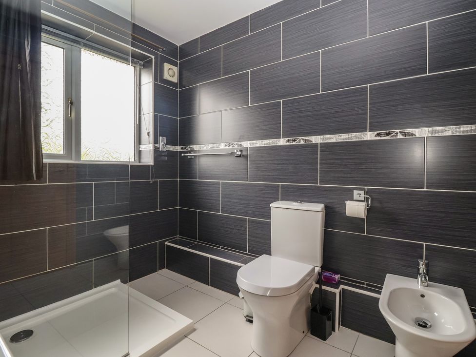 A bathroom with a shower, toilet, and bidet at Lillieput Lodge, Melbourne