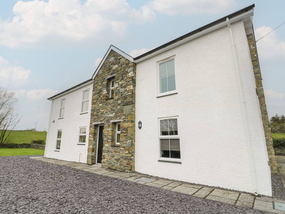A house with a stone wall and windows at Chapel House in Elim near Llanddeusant