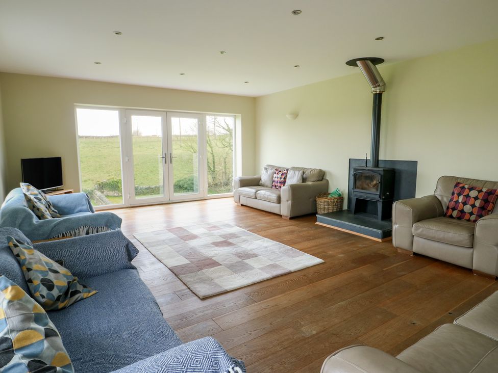 A living room with a wood burner and sofas at Chapel House in Elim near Llanddeusant