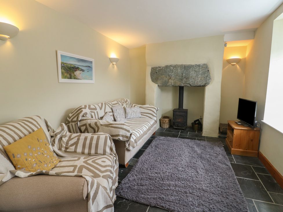 A living room with a wood stove and television at Chapel House Elim near Llanddeusant