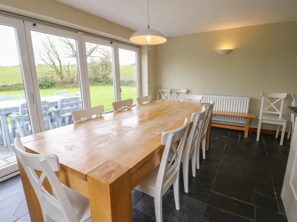 A dining room with a large table and chairs at Chapel House Elim near Llanddeusant