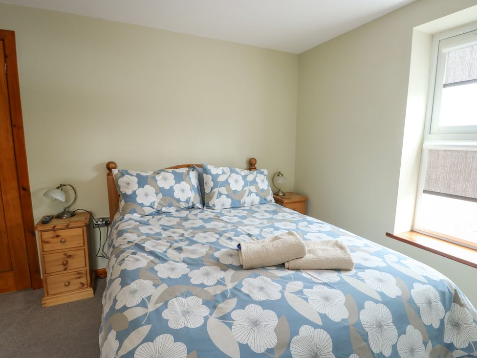 A bedroom with a bed and bedside lamp at Chapel House Elim near Llanddeusant