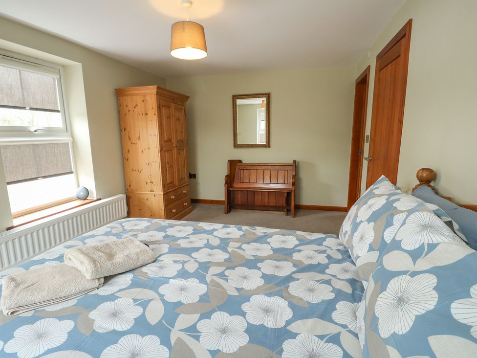 A bedroom with a bed and a wardrobe at Chapel House Elim near Llanddeusant