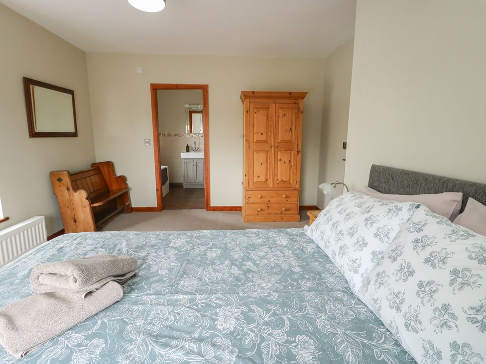 A bedroom with a bed and wardrobe at Chapel House Elim near Llanddeusant