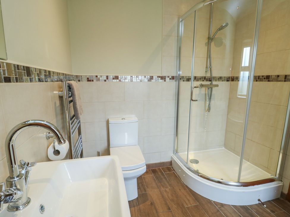 A bathroom with a shower, sink, and toilet at Chapel House in Elim near Llanddeusant