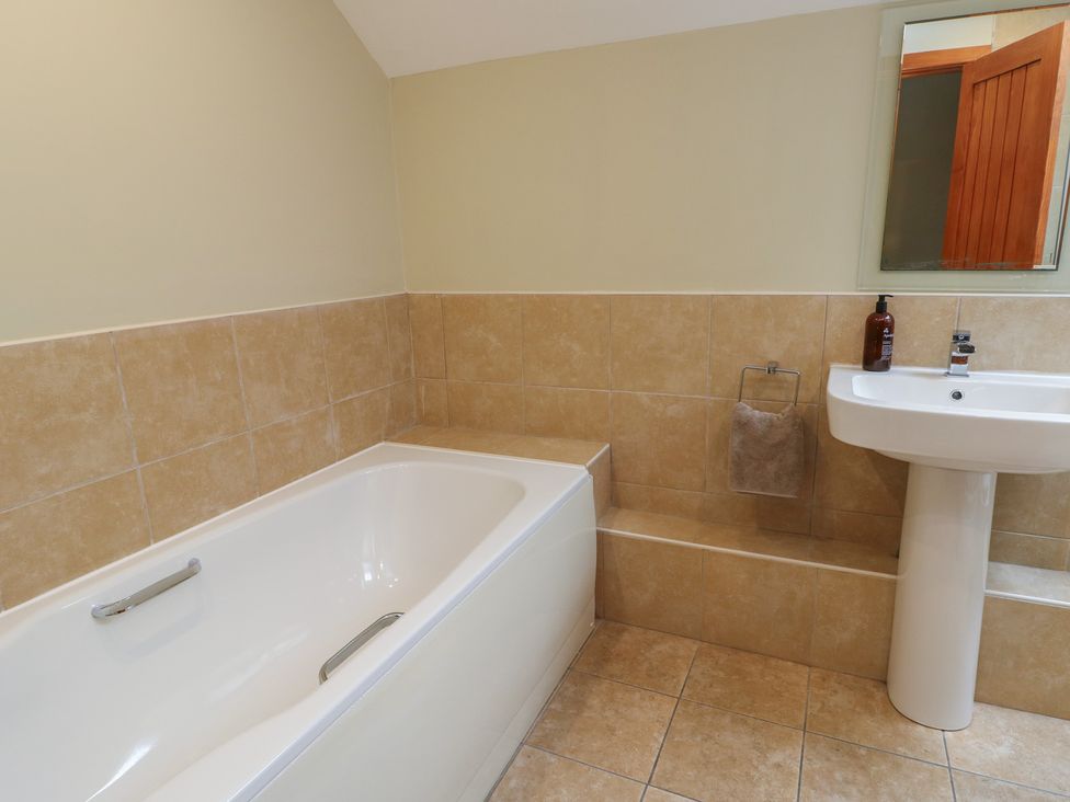 A bathroom with a bath tub and sink at Chapel House in Elim near Llanddeusant