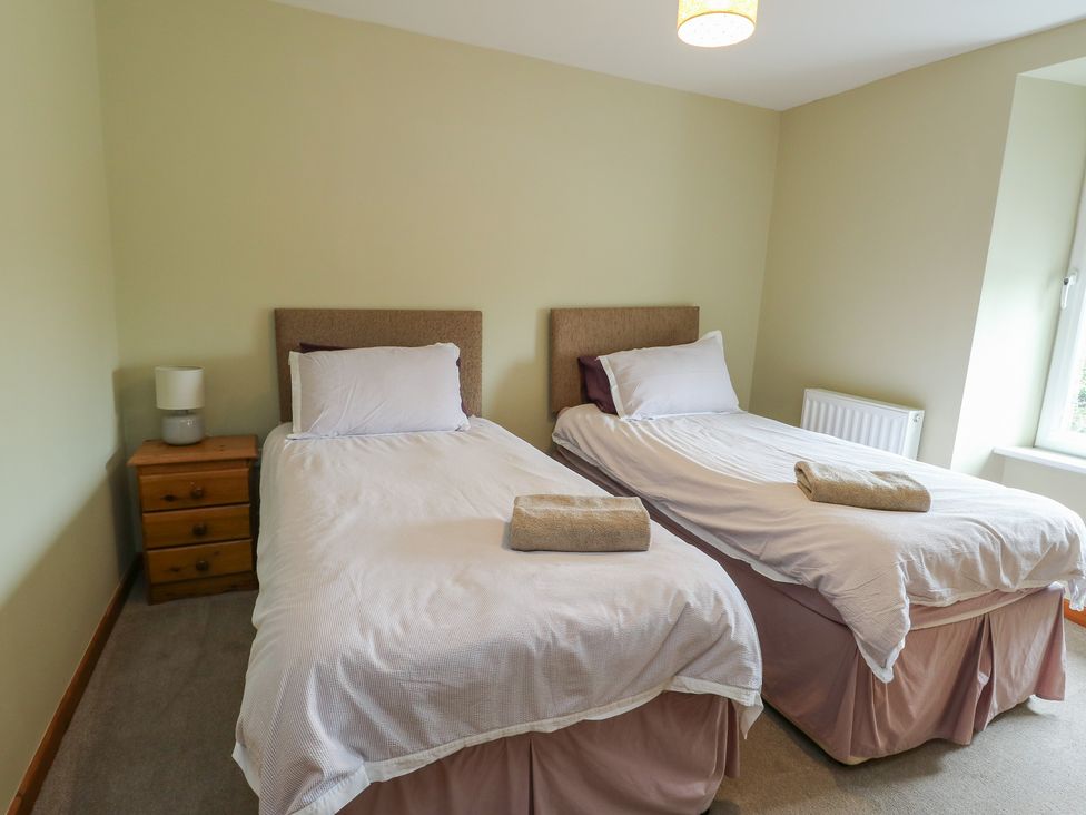 A bedroom with two single beds at Chapel House Elim near Llanddeusant