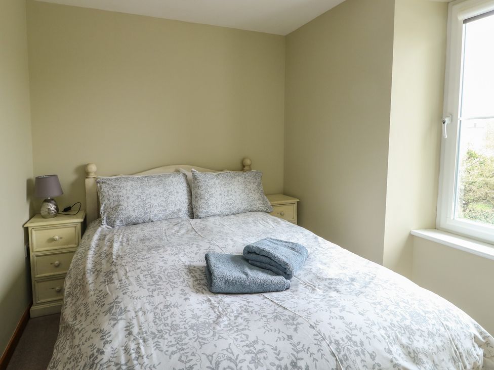 A bedroom with a bed and towels at Chapel House Elim near Llanddeusant