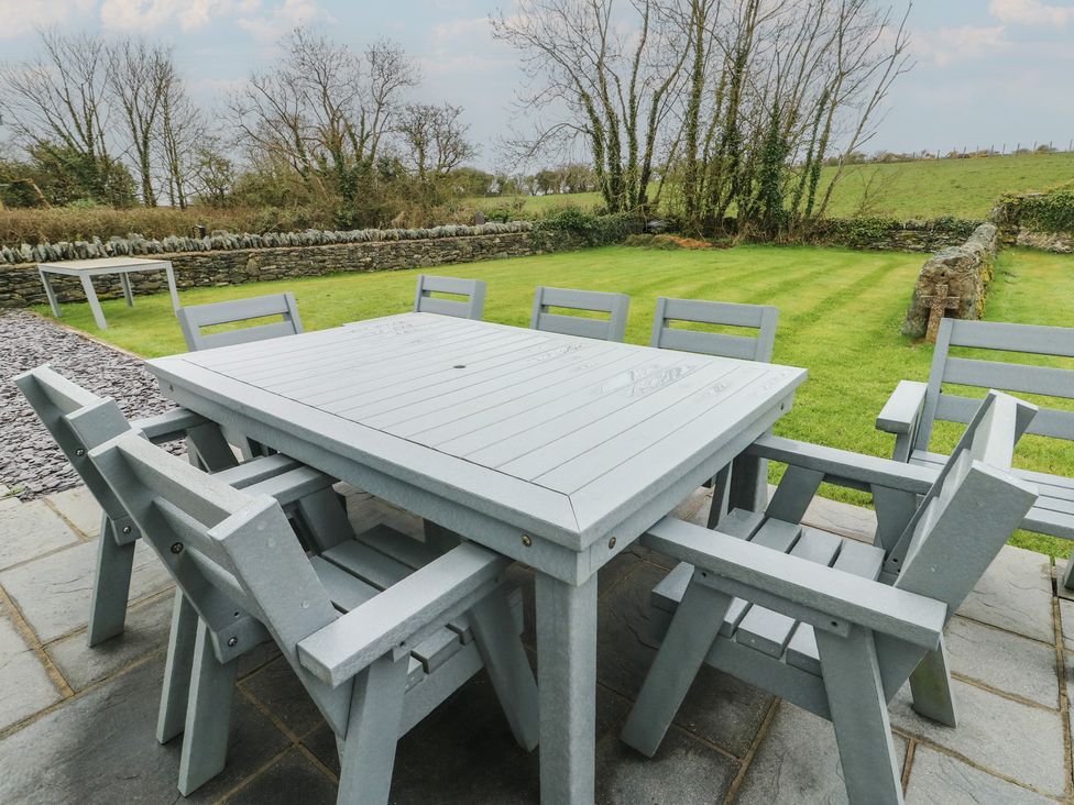 A garden with a table and chairs at Chapel House Elim near Llanddeusant